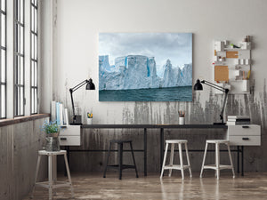 Irregular iceberg cliffs rise above dark Southern Ocean water.