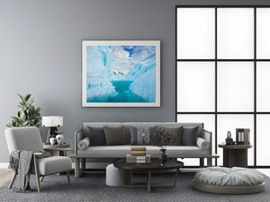 Deep blue folds and creases rise beside a bright Antarctic water pool.