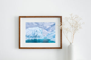 A central water channel opens between sculpted iceberg shapes beneath varied cloud patterns.