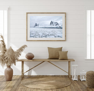Pale sea ice contrasting with rugged mountains on an Antarctic coast.