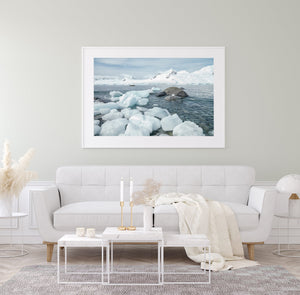 Snow-covered mountains across the sea beyond Antarctic shore ice.