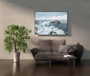 Cool blue Antarctic coastal landscape with foreground ice and distant peaks.