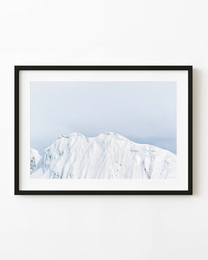 Snow-covered Antarctic ridge beneath a pale blue-grey sky.