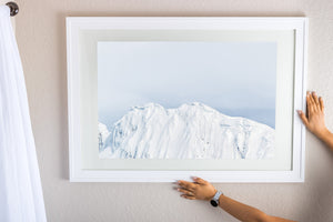White Antarctic slopes beneath a broad area of quiet pale sky.