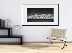 Bright Antarctic mountain ridges between ocean and sky in monochrome.