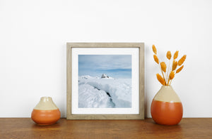 Textured snow banks framing a distant Antarctic rock summit.