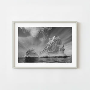 Large Antarctic iceberg rising from dark ocean in black and white
