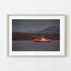 Icebreaker with red hull near Ushuaia Argentina at sunset
