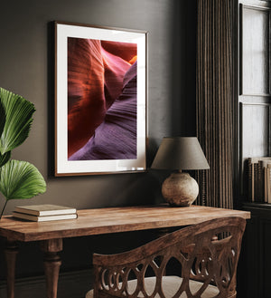Vertical Antelope Canyon photograph with layered stone and warm light above.