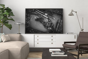 Antique tools and bolts arranged in a shallow metal tray in monochrome.