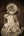 Warm toned portrait of an antique porcelain doll with a broad lace bonnet.