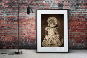 An antique doll with curled hair, long ribbons and a layered lace dress.