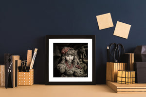 Selective colour photograph of an antique porcelain doll with red ribbons and soft curls.