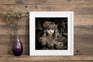 Red ribbons contrast with the softly toned face and dress of an antique porcelain doll.
