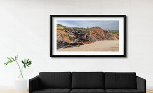Warm earth colours mark Aquinnah cliffs beneath a soft sky and distant lighthouse.