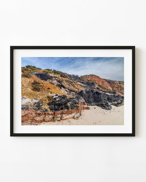 Layered red, ochre and charcoal clay cliffs above a sandy beach at Aquinnah, Martha’s Vineyard.