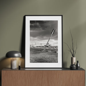Clouds gather above a leaning metal arrow sculpture in the Arizona landscape.