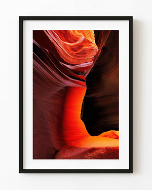 Red and orange sandstone curves around a dark overhang inside an Arizona slot canyon.