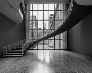 Curved museum staircase and window grid at the Art Institute of Chicago in monochrome.
