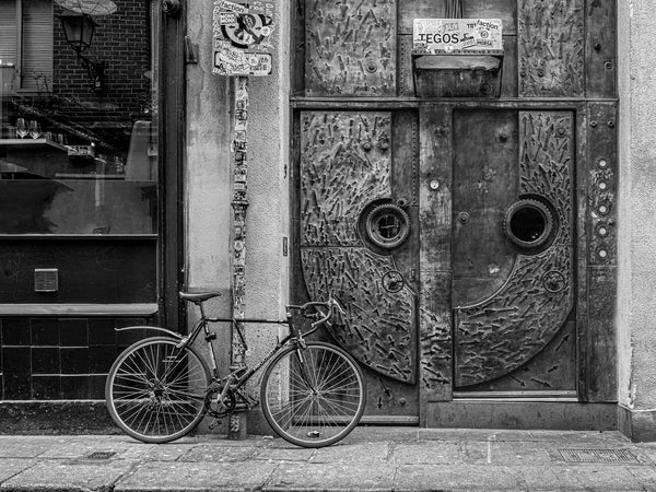 Black and white photo of vintage bicycle by artistic door