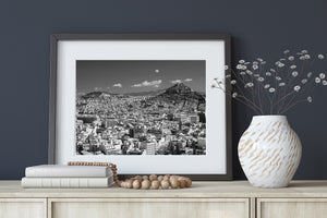 Black and white view across Athens architecture toward hills under an open sky.