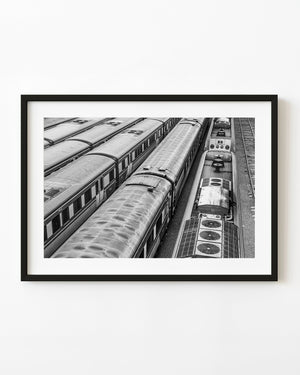 Parallel train carriages fill an Australian rail yard viewed from above in black and white.
