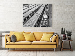 Dark gaps between parallel carriages reveal rails and gravel in an Australian train yard.