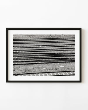Parallel Australian railway tracks and switch points cross gravel beds in black and white.