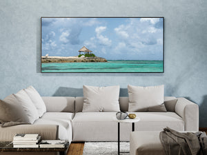 A wide blue sky and layered white clouds rise above turquoise Caribbean water.