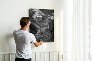 Black and white Banff landscape with snowy ridges, layered cliffs and a deep alpine valley.