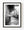 A blurred figure passes through a Barcelona night laneway beneath starburst lamps in black and white.