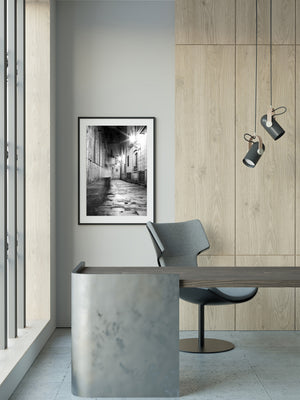 Starburst lights repeat along the right wall above uneven reflections on wet paving stones.