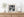 Short bollards repeat along both pavements beneath flags, balconies and small street signs.