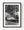 A white Volkswagen Beetle is parked beneath Barcelona balconies and dark windows at night in black and white.