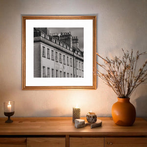 Dark marks beneath window sills and the parapet add texture to the pale stone facade.