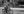 Panoramic street photograph of an older Toronto cyclist wearing a long coat and reflective vest.
