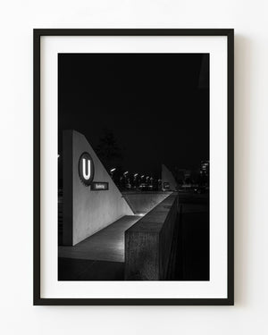 Illuminated U sign at Berlin’s Bundestag station entrance in black and white at night