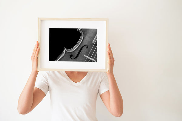 Violin close-up showing wood grain and strings – black and white