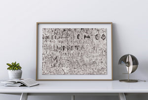 Large lettering crosses finer carved marks in weathered stone.