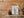Ladderlike rigging and crosspieces surround a tall wooden schooner mast.