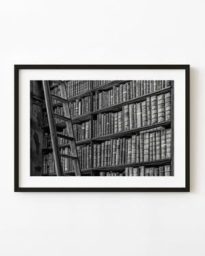 Books and a wooden ladder at Trinity College Library in Dublin, photographed in black and white