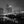 Illuminated Boston buildings rise beyond a bridge above dark water