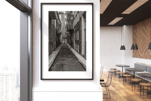 Monochrome urban photograph of Boston windows, pipes and metal stairs