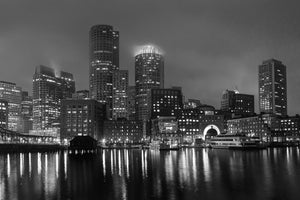 Fog softens Boston’s waterfront towers above long night reflections