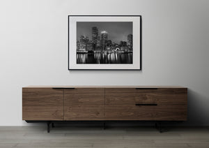 Monochrome Boston cityscape with bright windows and dark harbour water