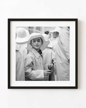 Boy wearing a broad hat in a Tuscan festival parade in black and white