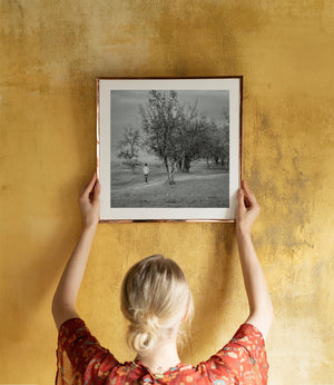 Tree-lined path in monochrome Tanzanian village