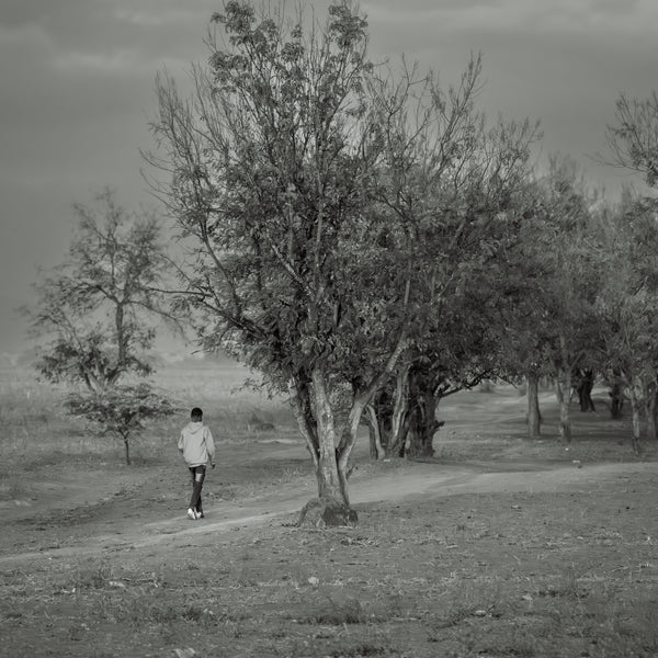 Boy walking down the path in rural Tanzania | Photo Art Print