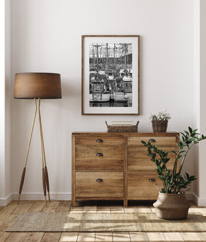 Black and white maritime scene with reflections below crowded boat sterns.