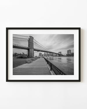 Brooklyn Bridge and the East River waterfront in New York City, photographed in black and white.